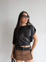 Top asimétrico negro de tul brillante elastizado, con diseño de corte irregular y caída en punta.
