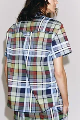 Camisa de manga corta de algodón, con cuello de solapa, cierre frontal de botones y bajo recto, con estampado de cuadros multicolores.