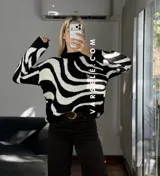 Sweater de tejido de punto con diseño de ondas en color marrón y crema, de cuello redondo y manga larga.