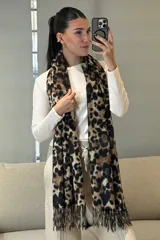 Bufanda rectangular con estampado animal print de leopardo en tonos marrones y negros, con terminación de flecos en los extremos.