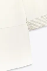 Blazer blanco de lino con cuello solapa, manga larga con hombreras y puños con vuelta estampada. Tiene bolsillos delanteros con solapa y cierre frontal con botón.