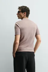 Polo de manga corta con cuello solapa y cierre frontal de botones. Confeccionado en tejido de punto con acabado en rib en puños y bajo.