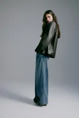 Jean wide leg de denim azul con lavado medio, tiro regular, diseño de cinco bolsillos y perneras amplias y rectas.