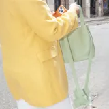Cartera mini bag de cuero graneado color verde agua, con doble asa de mano y correa larga desmontable que presenta un detalle decorativo de volados. Cuenta con cierre a presión.