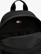 Mochila de diseño redondeado color negro, con compartimento principal amplio, bolsillo exterior con cierre y correas ajustables y acolchadas. Cuenta con parche distintivo de Tommy Jeans en la parte delantera.
