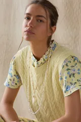 Chaleco amarillo de hilo con diseño trenzado.