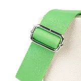 Bolso tipo tote de tela color crudo con detalles en cuero sintético verde. Tiene doble asa corta, correa larga regulable y extraíble, bolsillo frontal con cierre, cierre principal, bolsillo interno con cierre y dos bolsillos internos abiertos.