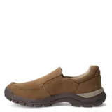 Zapatos tipo slip-on Caterpillar, confeccionados en lona color beige, con suela de goma robusta en tono marrón y detalle de marca en el lateral.