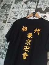 Remera negra de manga corta con estampado de letras japonesas en color naranja.