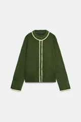 Chaqueta de punto color verde oscuro con cuello redondo y cierre frontal de botones. Presenta detalles de vivos en color crema en el cuello, la tapeta de botones y los puños.