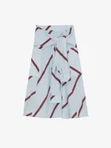 Falda larga cruzada de viscosa y poliamida, color celeste con estampado de líneas diagonales bordó. Presenta silueta amplia, bolsillos laterales y detalle de mangas de camisa incorporadas en la cintura para anudar.