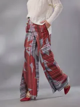 Pantalón de cintura alta y piernas amplias en lino mezcla, con estampado vegetal en tonos bordó, gris y blanco, y tajos asimétricos en las piernas. Cuenta con cierre invisible lateral y bolsillos.
