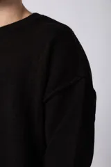 Sweater de punto grueso en color verde oliva, con diseño oversized, cuello redondo y mangas largas con puños acanalados.