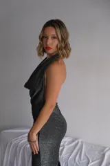 Vestido largo de lycra color gris oscuro con brillo, escote drapeado tipo halter y silueta ajustada.