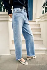 Jeans de tiro medio y corte relaxed fit, color azul con efecto deslavado, diseño de cinco bolsillos y bajo vuelto. Cuenta con cierre frontal de cremallera y botón metálico.