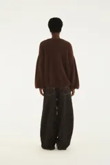 Pantalón de jean tiro alto y corte wide leg, con estampado animal print tipo cebra en tonos marrón y negro. Cuenta con bolsillos laterales y costuras pespunteadas en contraste.