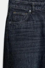 Jeans de mezclilla de tiro medio, corte recto y silueta curva con efecto lavado, bajo asimétrico y diseño de cinco bolsillos.