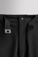 Bermuda de ajuste regular color marrón oscuro, confeccionada en tejido técnico compacto con elasticidad. Presenta cintura ajustable con cinturón negro a contraste, bolsillos frontales y un bolsillo cargo con cierre de cremallera oculta en la pernera.