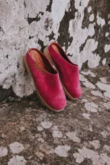 Mules de gamuza color fucsia con suela de goma color caramelo.