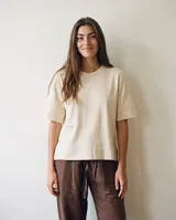 Remera de algodón color crudo, con escote redondo, mangas cortas amplias y calce relajado.