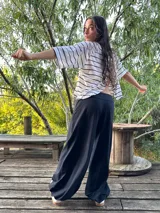 Blusa color beige de viscosa elastizada, con cuello bote y espalda cruzada. Estampado frontal con ilustración de una cara con corona de flores.