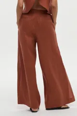 Pantalón de pierna ancha confeccionado en lino color ladrillo, con cintura elástica y cordón ajustable.