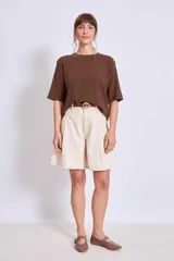 Bermuda color crema de corte ancho, con cintura alta y presillas para cinturón.