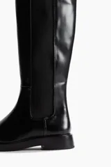 Botas de caña alta negras de cuero sintético, con diseño tipo Chelsea de punta redondeada, paneles elásticos laterales y tirador trasero.
