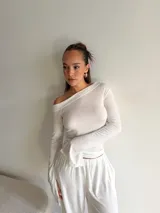 Blusa de lanilla color beige, con escote asimétrico tipo barco y mangas largas con terminación acampanada.