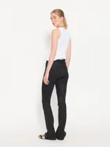 Pantalón de jean negro de tiro alto, corte acampanado y textura rayada vertical.