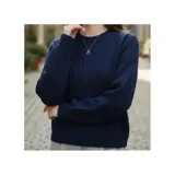 Buzo de manga larga color azul marino con diseño de tejido trenzado, cuello redondo y puños y ruedo elásticos acanalados.