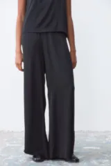 Pantalón negro de corte palazzo con cintura elástica.