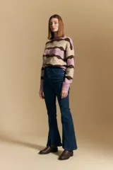 Jean oxford de tiro alto confeccionado en denim con spandex, de color gris oscuro lavado. Presenta un corte ajustado en la parte superior que se ensancha hacia el ruedo, el cual incluye aberturas frontales.