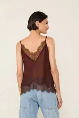 Top de viscosa color marrón, sin mangas, con tirantes ajustables, escote en V pronunciado, diseño transparente con detalles de encaje aplicado y terminaciones en ondas.