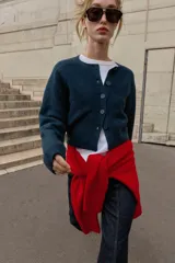 Chaqueta de punto de cuello redondo y manga larga, con cierre frontal de botones y acabados en rib.