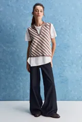 Chaleco tejido de punto con diseño de rayas diagonales en color marrón y beige, cuello polo y escote en V profundo.