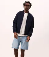 Campera tipo bomber de color azul marino, con cuello, puños y ruedo acanalados. Presenta cierre frontal por cremallera, bolsillos laterales y tecnología repelente al agua. Diseño de corte clásico con forro interior.