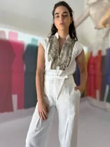 Mono largo azul marino con estampado dorado en la parte superior, cuello mao, sin mangas, con cinturón y bolsillos laterales.