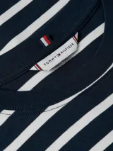 Remera Tommy Hilfiger de corte slim, con cuello redondo y mangas cortas. Diseño a rayas horizontales azul marino y blancas. Logo de la marca bordado en el pecho.