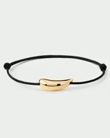 Pulsera PD Paola con cordón negro y dije dorado en forma de flecha.