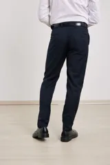 Pantalón de vestir azul marino, de corte recto, con bolsillos laterales y traseros. Se ajusta a la cintura con cinturón de cuero negro.