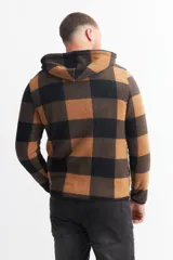 Campera con capucha, forrada en piel sintética, con cierre frontal y diseño a cuadros grandes en tonos verde y negro.