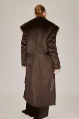 Abrigo largo de Zara Woman Collection en color marrón chocolate, con cuello de solapa amplio, mangas largas y cinturón ajustable del mismo tejido. Presenta detalles de forro interior y acabados en efecto pelo a tono en cuello, puños y bordes frontales.