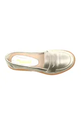 Mocasín plateado de cuero con detalle de vincha y suela plana color madera.