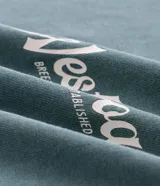 Remera de algodón con efecto lavado gastado, cuello redondo y mangas cortas. Presenta un diseño con estampa frontal localizada con lettering West Coast y un calce levemente suelto.