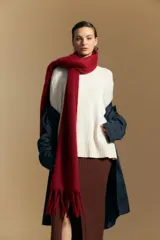 Polera de cuello redondo y corte relajado, confeccionada en tejido de punto color blanco crema. Presenta terminaciones acanaladas en el cuello, los puños y el ruedo, ofreciendo una textura suave y una caída liviana.