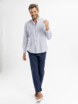 Camisa de manga larga con diseño de rayas finas verticales, cuello con botones y bolsillo frontal. Confeccionada en una mezcla de poliéster y algodón, presenta un calce regular y cierre frontal con botones.