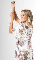 Vestido midi de gasa blanca con estampado floral chintz en tonos rosa y gris, de corte amplio y liviano.