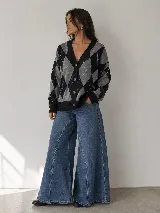Saco de punto con estampado de rombos en tonos negro y gris. Presenta escote en V, cierre frontal con botones y mangas largas con puños acanalados.
