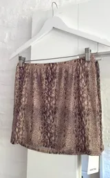 Pollera corta de microtul con estampado animal print de serpiente, de corte ajustado y cintura elástica.